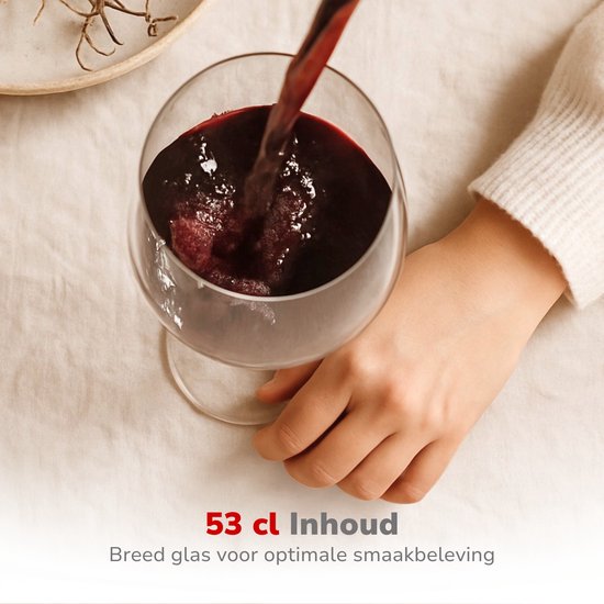 Breed glas 53 cl gevuld met rode wijn, ingeschonken door een hand.