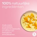 Goudgele bloemblaadjes in een schaal met olie. 100% natuurlijke ingrediënten, zoals zoete amandelolie.