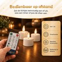 Hand die een afstandsbediening van Dorsetto vasthoudt bij drie oplaadbare led-kaarsen op een tafel.