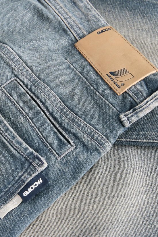 Detail van blauwe denim jeans met een leren label van Jack & Jones.
