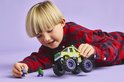 Jongen met groene LEGO monster truck, Hulk en paarse minifiguur.
