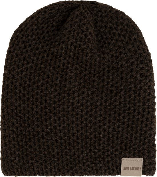 Donkerbruine, grof gebreide muts met een beige Knit Factory-label aan de onderzijde, geïsoleerd op wit.