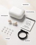Inhoud van de verpakking: beige hoortoestellen, oordopjes, oplaadcase, producthandleiding en oplaadkabel.