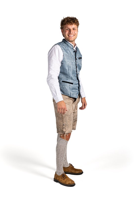 Homme portant un gilet jacquard bleu clair, un short en cuir beige, une chemise blanche et des chaussettes grises.