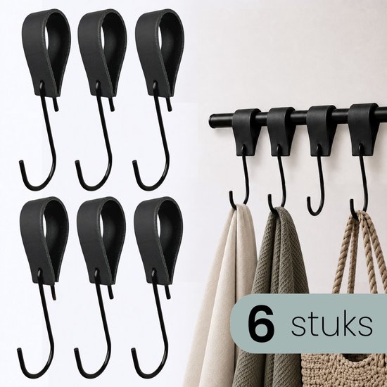 Zes zwarte leren s-haak hangers, los en aan een zwarte rail met handdoeken en tas.