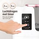 Hand drukt op zwart touchpaneel van witte elektrische make-upkwastenreiniger met de tekst '2 uur' en '5 uur' erboven.