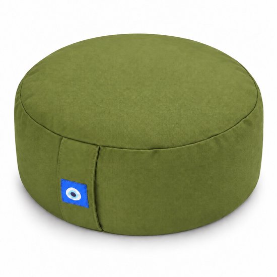 Rond groen meditatiekussen met een klein blauw oog-label aan de zijkant, geïsoleerd op een witte achtergrond.