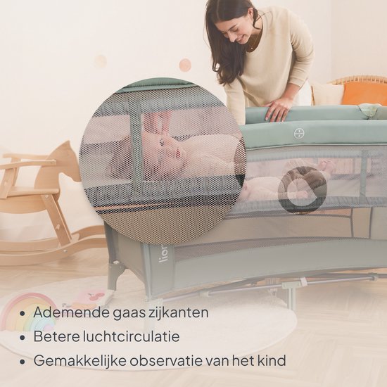 Moeder kijkt naar baby in een groen Lionelo reisbedje met ademende gaaszijkanten voor betere luchtcirculatie.
