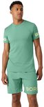 Man in lichtgroen sportshirt met korte mouwen en short, met gele tekst op de mouw en short.