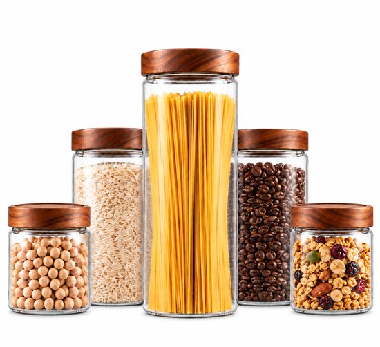 Vijf glazen voorraadpotten met acaciahouten deksels, gevuld met pasta, rijst, koffiebonen, noten en bonen.