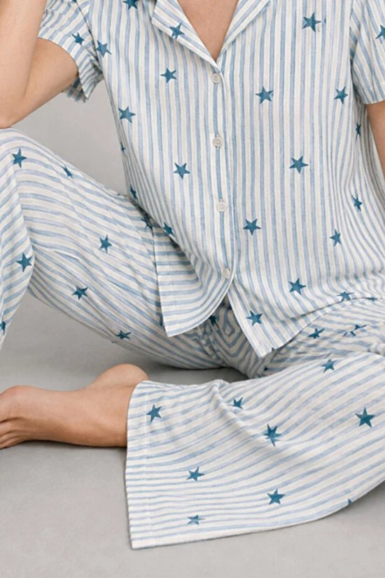 Close-up van pyjamashirt en broek met lichtblauwe strepen en donkerblauwe sterrenprint.
