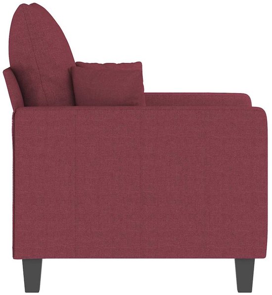 Zijaanzicht van een wijnrode fauteuil in stof met een gestroomlijnd ontwerp en zwarte poten.