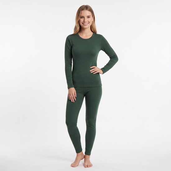 Vrouw in een donkergroene thermische set met lange mouwen en broek, staand met hand in de zij.