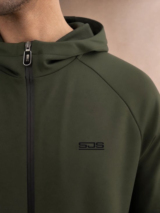 Close-up van de borst van een man in een olijfgroene hoodie met capuchon, rits en zwart SJS-logo.