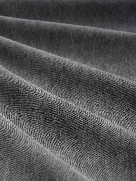 Gedetailleerde close-up van grijs denim stof met golvende plooien.