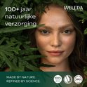 Vrouw met sproetjes omringd door groene bladeren. Tekst: 100+ jaar natuurlijke verzorging, MADE BY NATURE, REFINED BY SCIENCE.