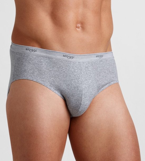 Grijze herenslip gedragen door model, met elastische tailleband voorzien van het Sloggi-logo.