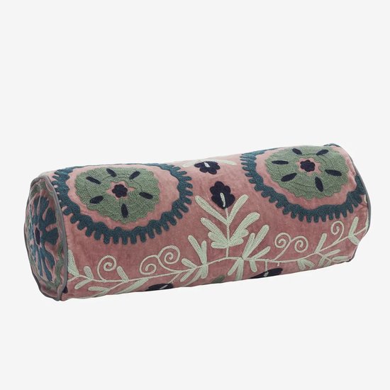 Liggend roze fluwelen rolkussen versierd met blauwe en groene geborduurde bloemen en ranken.