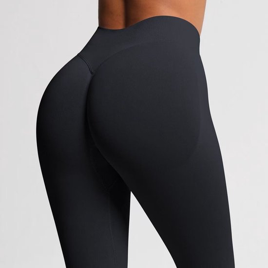 Detailopname achterzijde van zwarte sportlegging met scrunch-detail.