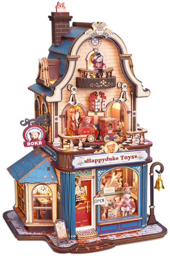 Diorama van een speelgoedwinkel, "Happyduke Toys", met een blauw dak, rode deur en miniatuur speelgoed, geplaatst op een stenen pad.