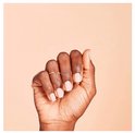 Een donkere hand met naturel gelakte nagels en twee ringetjes.