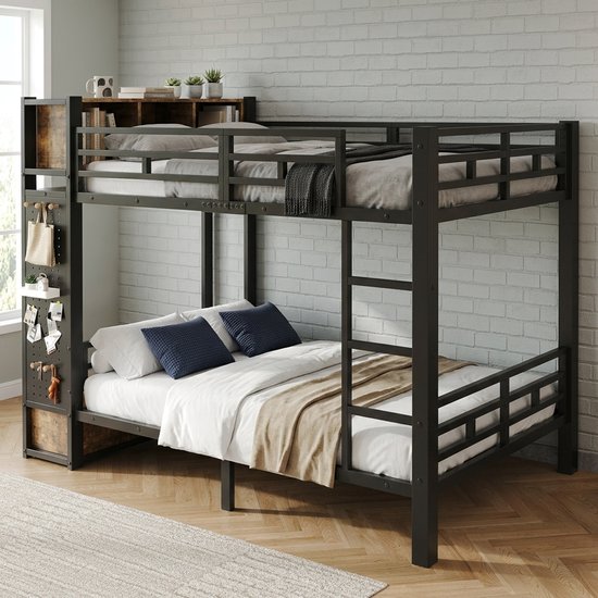 Opgemaakt zwart metalen stapelbed met houten opbergvakken, kledingroede en lades, naast een witte bakstenen muur.