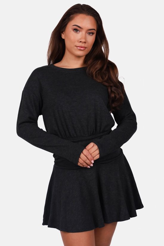 Gros plan sur une robe noire à col rond, manches longues et taille élastique ajustée.