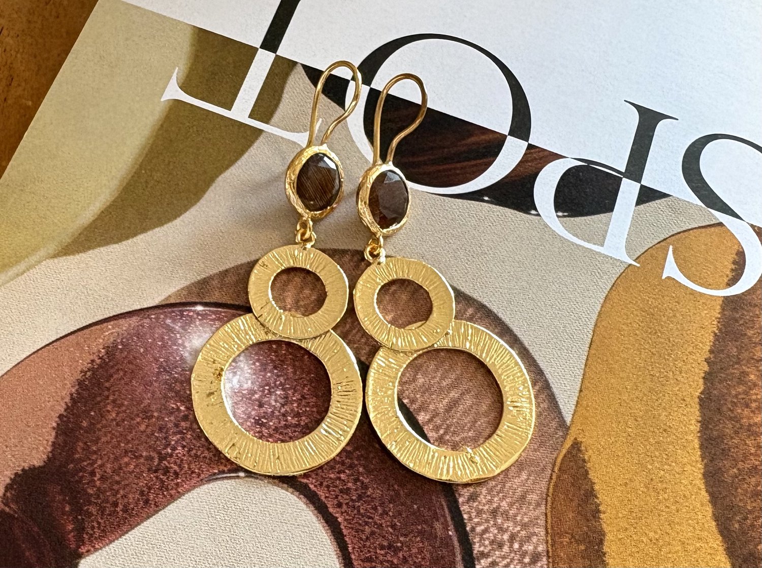 Oorbellen gouden cirkels cateye steen bruin