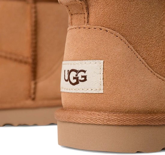 Detail van het UGG-logo op de hiel van bruine UGG Classic Mini II kinderlaarzen.