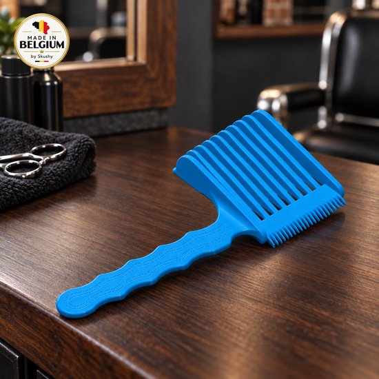 Blauwe wave-kam met brede tanden op een houten tafel, met 'Made in Belgium' zegel in de hoek.