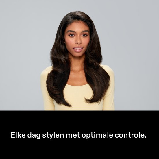 Vrouw met lang, donkerbruin, golvend haar, met een gele trui. Elke dag stylen met optimale controle.
