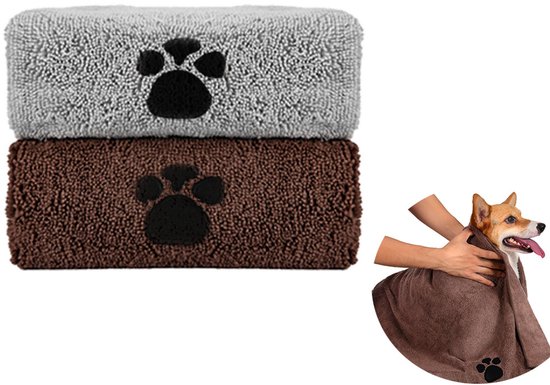 Een grijze en een bruine microvezel handdoek met pootafdruk gestapeld. Een corgi wordt afgedroogd met de bruine handdoek.