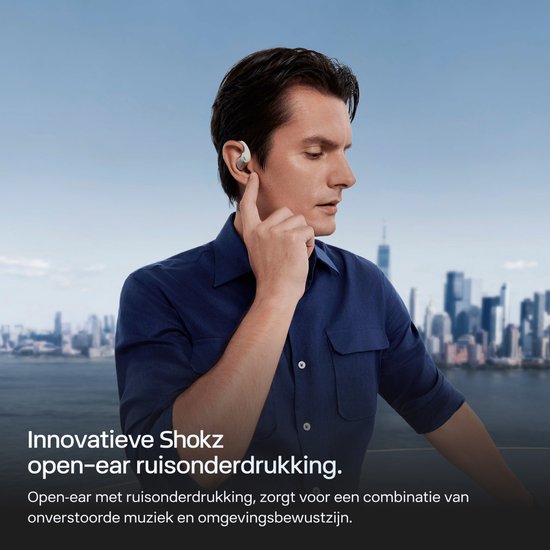 Man met blauw overhemd, draagt witte Shokz oordopjes met ruisonderdrukking.