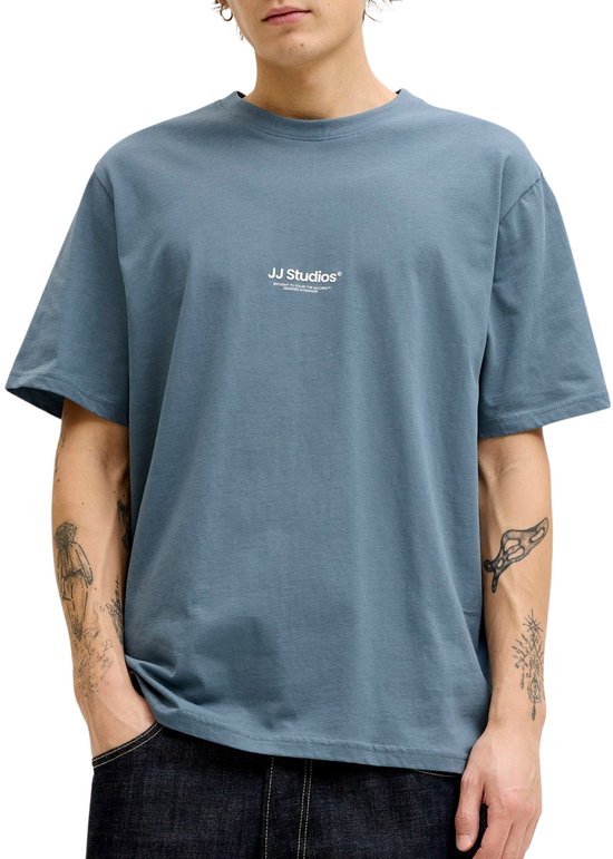 Gros plan d'un t-shirt bleu avec l'inscription blanche 'JJ Studios' sur la poitrine.