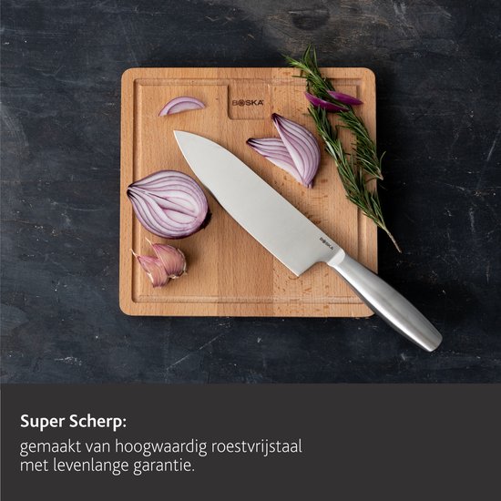 Koksmes op een houten snijplank met rode ui en rozemarijn. Tekst: "Super Scherp: gemaakt van hoogwaardig roestvrijstaal met levenslange garantie."