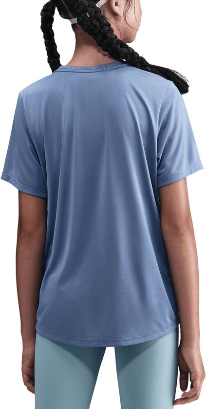 Meisje met gevlochten haar draagt een blauw Nike t-shirt, voorkant met witte swoosh, achterkant effen.
