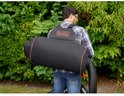 Man met rugzakbladblazer met grote zwarte opvangzak, oranje randen, in de tuin.