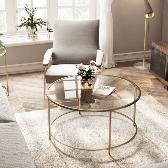 Ronde bijzettafel met glazen blad en goudkleurig metalen frame in een modern interieur.