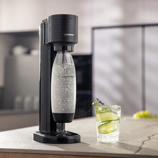 Zwarte Sodastream Gaia bruiswatertoestel met bruiswater, naast een glas met drank.