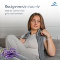 Jonge vrouw met grijs Chillaxy kussen om de nek, met lavendel op de bank.