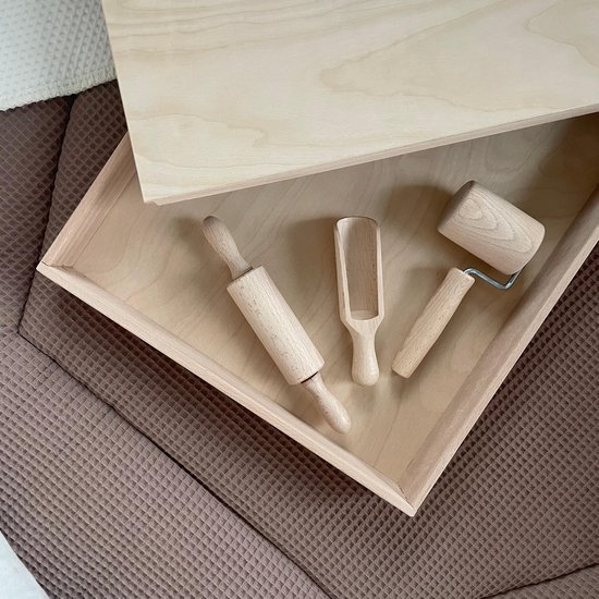 Houten speelgoed: deegroller, schepje en mini-deegroller in een houten bak.