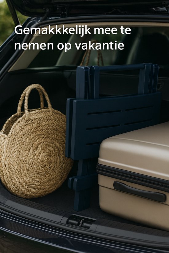 Donkerblauwe inklapbare tafel naast een koffer en rieten tas in een auto.