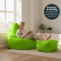 Vrouwen lezen op een limegroene zitzak met bijpassende poef, in een lichte woonkamer.