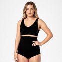 Model in zwarte shapewear top en slip, staand met hand op heup.