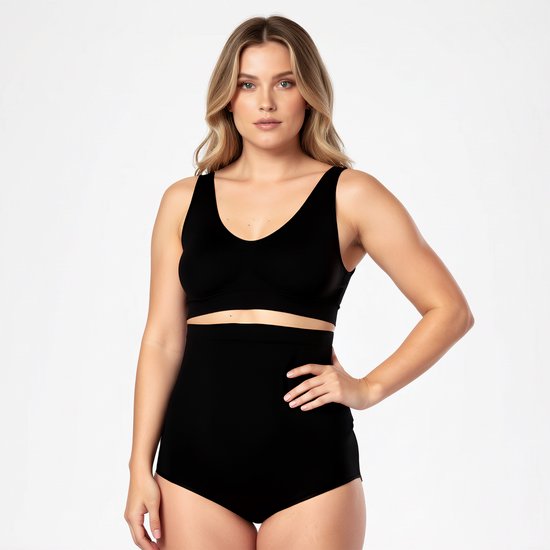 Model in zwarte shapewear top en slip, staand met hand op heup.