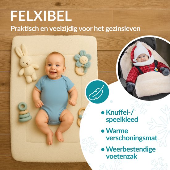 Bébé sur un tapis de jeu Monzana crème avec peluches. Sac de couchage bébé en arrière-plan.