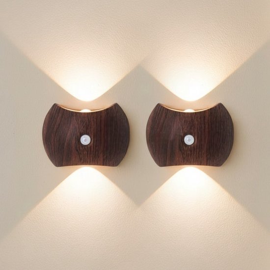 Twee identieke walnootkleurige wandlampen met opwaartse en neerwaartse lichtbundels, gemonteerd op een lichte muur.