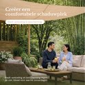 Koppel geniet van de schaduw onder een beige O'DADDY schaduwdoek in een tuin met bamboe.
