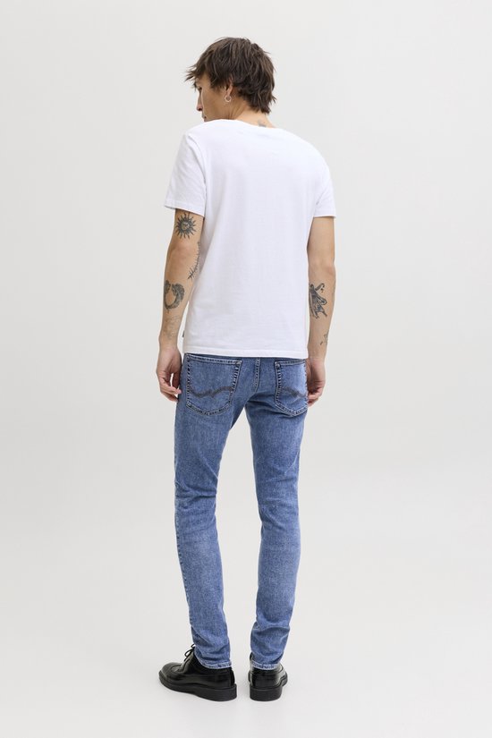 Blauwe slim fit jeans met een lichte wassing, gedragen door een man.