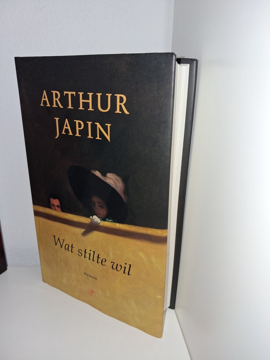 Boek "Wat stilte wil" van Arthur Japin. Donkerbruine cover met gele rand en schildering van een persoon met hoed.